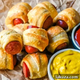 These Pigs in a Blanket are a classic, crowd-pleasing appetizer with juicy hot dogs wrapped in flaky crescent dough and baked until golden. These crescent roll hot dogs are so easy to prepare and you can even customize them into pretzel dogs. This is such an easy party appetizer to whip up in less than 30 minutes.