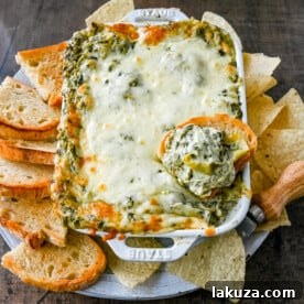 Hot Spinach Artichoke Dip. This easy spinach artichoke dip is creamy and cheesy and always a crowd pleaser! This warm spinach artichoke dip is served with tortilla chips, crackers, or bread for the perfect dip recipe.