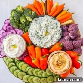 How to make a beautiful Crudite Platter with vegetables and dips. I am sharing my favorite veggie dip recipes, what vegetables to put on a veggie tray, and how to arrange one. It is so easy to make a stunning vegetable platter!