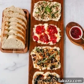A Butter Board with fresh butter is spread onto a board and topped with an assortment of toppings and served with warm bread. This Butter Board with Toppings is such a fun appetizer for a party! A Butter Board is made by spreading salted, slightly softened butter onto a board and topping it with your favorite toppings like jam and fresh lemon zest and hot honey, walnuts, and fig jam. A savory butter board can be made with butter, roasted garlic, fresh basil, italian seasoning, and red chili flakes. Warm French bread slices are dipped into each savory or sweet butter combination. This Butter Board became famous on TikTok and is now a popular appetizer at parties.