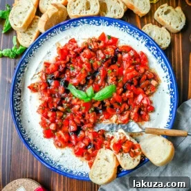 This quick and easy appetizer is made with garlic and herb Boursin cheese and topped with a fresh caprese salad made with tomatoes, olive oil, balsamic glaze, basil, and garlic. This Caprese Dip with boursin cheese pairs perfectly with crostinis or crackers.