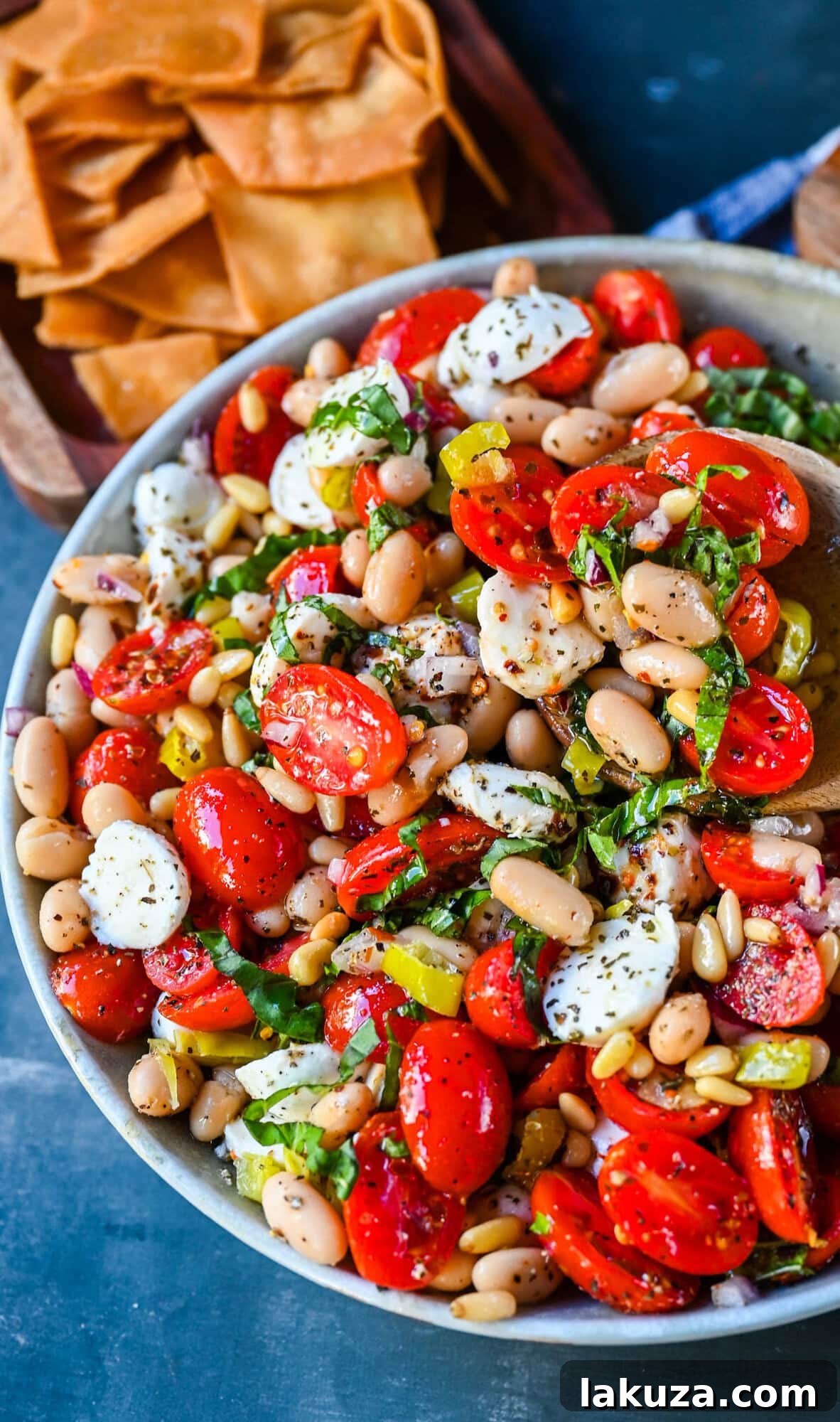 Various fresh ingredients for Italian Cowboy Caviar laid out on a cutting board.