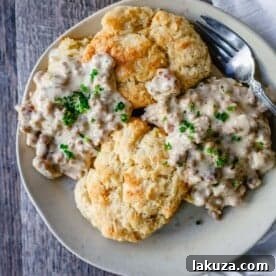 Homemade Biscuits and Gravy, featuring buttery, flaky biscuits topped with creamy, savory sausage gravy, praised as the best biscuits and gravy recipe.