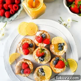 Mini Dutch Baby Pancakes baked in a muffin tin, bite-sized versions of traditional German pancakes, golden, buttery, and puffed, perfect for serving to family and friends.