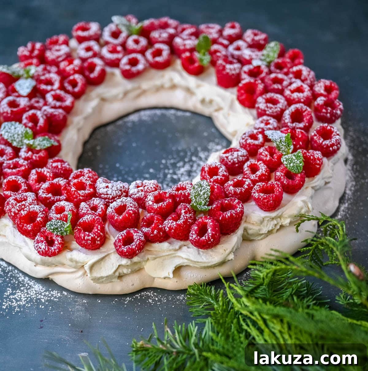 Festive Pavlova Cloud 2 A beautifully decorated Christmas Pavlova wreath with fresh raspberries and powdered sugar, ready for a festive holiday gathering.