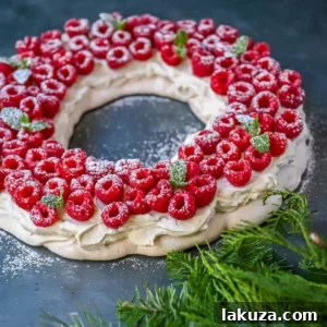 Festive Pavlova Cloud 9 A festive Christmas Pavlova with a crisp meringue shell, soft center, and mascarpone whipped cream topped with fresh raspberries.