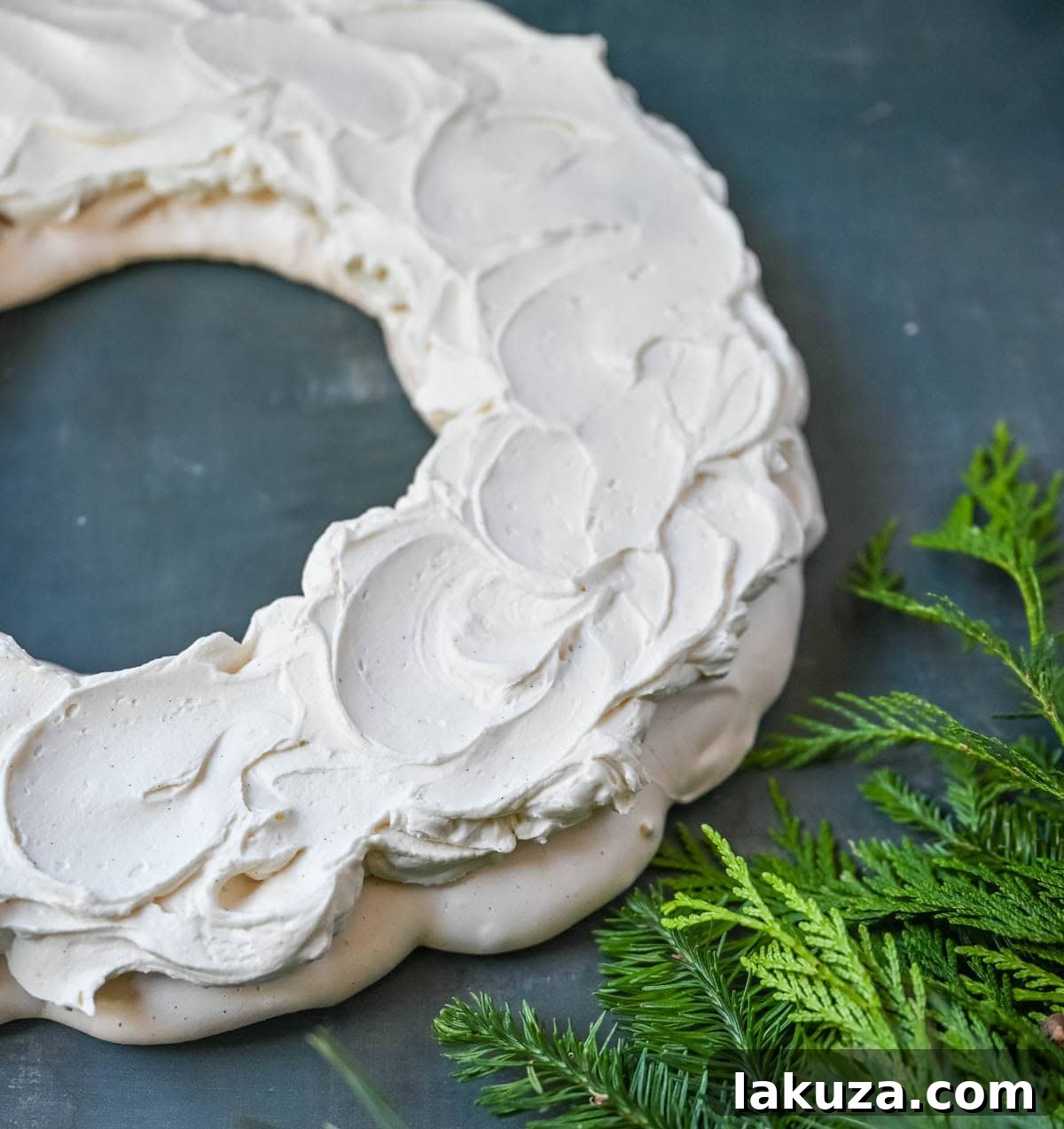 Festive Pavlova Cloud 6 A close-up of a festive Christmas Pavlova with mascarpone whipped cream and fresh raspberries, ready to be served.