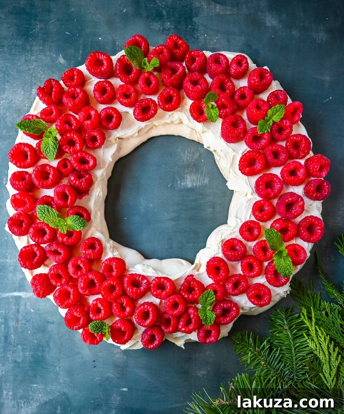 Festive Pavlova Cloud 7 A beautifully presented Christmas Pavlova on a white platter, surrounded by festive decorations.