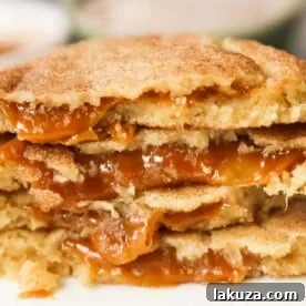 Caramel Filled Snickerdoodle Cookies Soft chewy cinnamon sugar snickerdoodle cookies stuffed with buttery caramel. The perfect caramel stuffed snickerdoodle cookie recipe! www.modernhoney.com #caramelsnickerdoodles #christmascookies #cookie #cookies