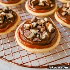 Twix Cookies made with soft sugar shortbread topped with rich caramel and milk chocolate and sprinkled with chopped Twix candy bars. These Millionaire Cookies are the best chocolate caramel shortbread cookie!