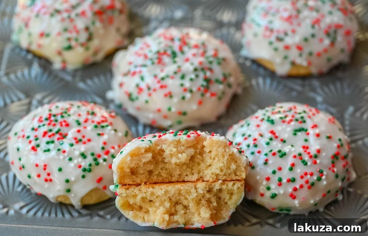 A beautifully arranged platter of freshly baked Italian ricotta cookies, some glazed and sprinkled, others plain, ready to be served.