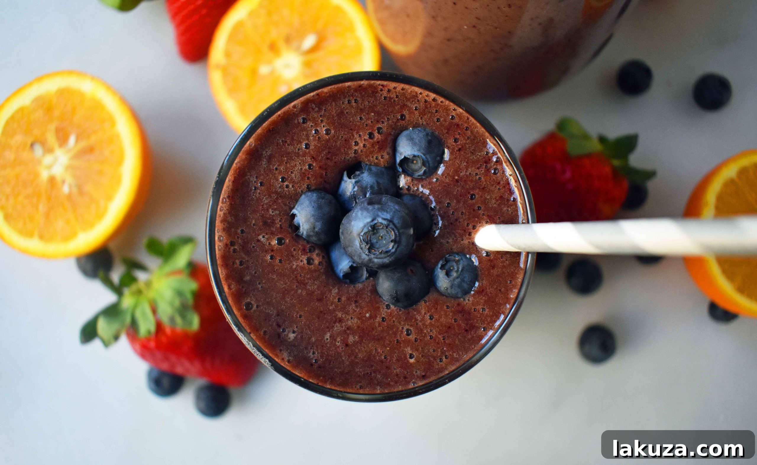 An overhead shot of The Energizer Spinach Berry Smoothie, garnished with fresh berries and spinach, invitingly displayed by Modern Honey. This image showcases the smoothie's visual appeal and fresh ingredients, highlighting it as a perfect healthy choice.