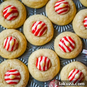 These Candy Cane Kiss Cookies are soft, buttery sugar cookies rolled in sparkling sugar or festive sprinkles, baked until just set, and then pressed with a striped peppermint Candy Cane Kiss right in the center. This Peppermint Kiss Cookie is such a festive Christmas cookie recipe.