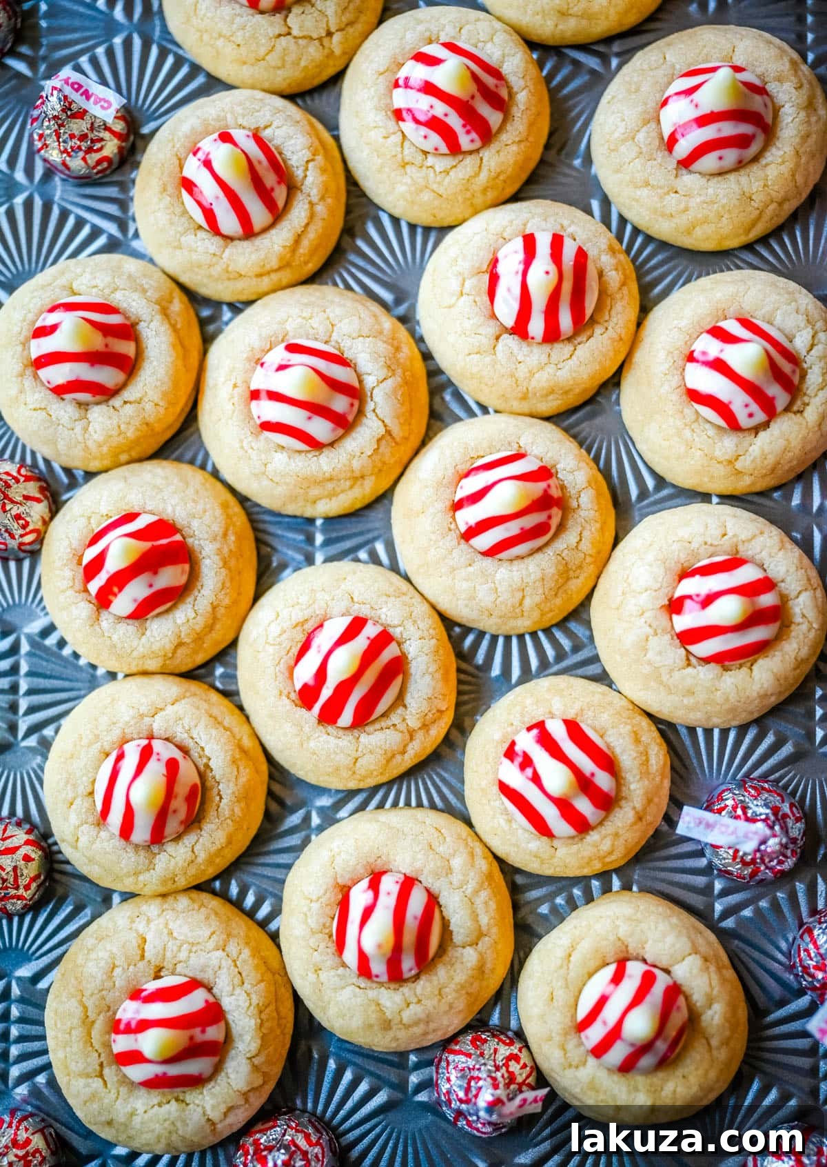Holiday Candy Cane Kiss Delights 3 A close-up of freshly baked Candy Cane Kiss Cookies on a cooling rack, each adorned with a perfectly melted peppermint Kiss.