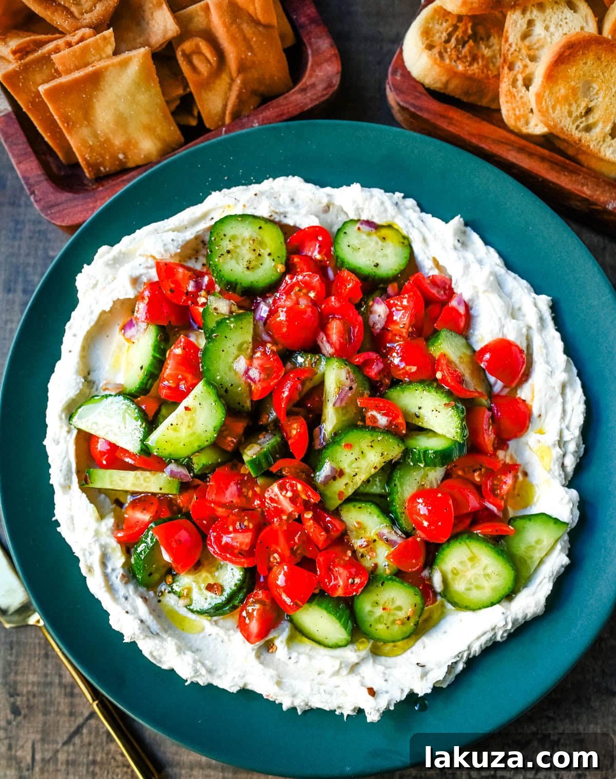 This Greek feta dip is the ultimate party and holiday appetizer that is rich, creamy, and so flavorful! It blends tangy feta, cream cheese, lemon, oregano, and olive oil into a silky whipped dip that feels fancy but takes just minutes to make. Pile it high with tomatoes, cucumbers, and a drizzle of olive oil, then serve with pita chips or veggies.