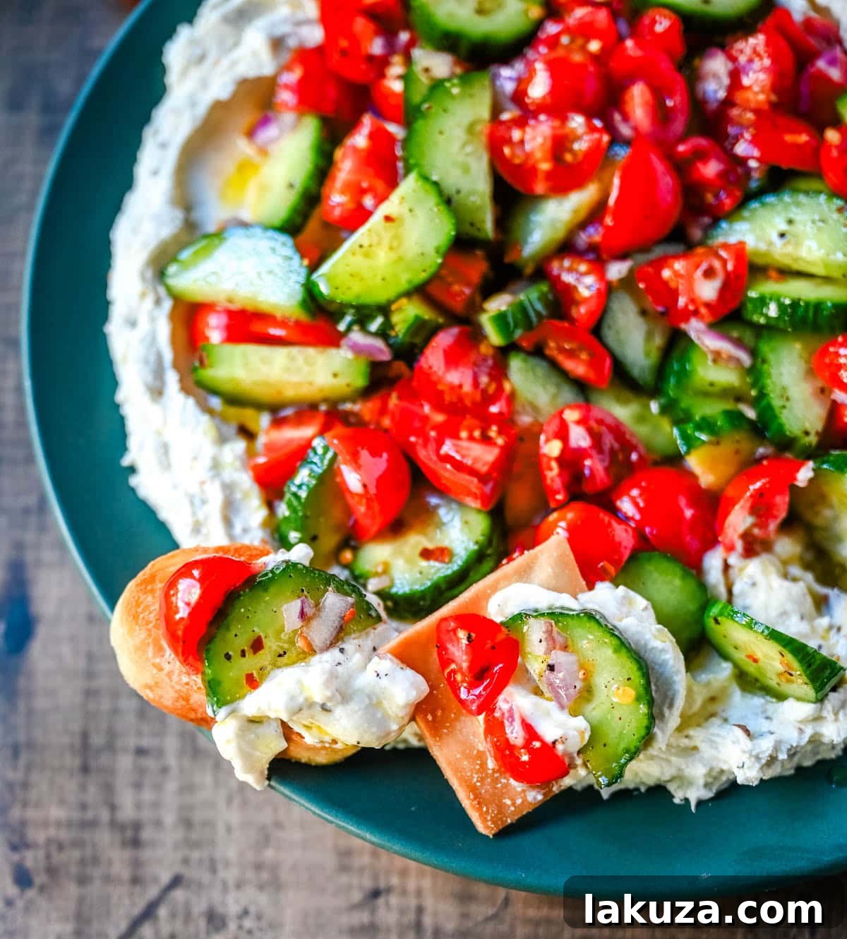 This Greek feta dip is the ultimate party and holiday appetizer that is rich, creamy, and so flavorful! It blends tangy feta, cream cheese, lemon, oregano, and olive oil into a silky whipped dip that feels fancy but takes just minutes to make. Pile it high with tomatoes, cucumbers, and a drizzle of olive oil, then serve with pita chips or veggies.