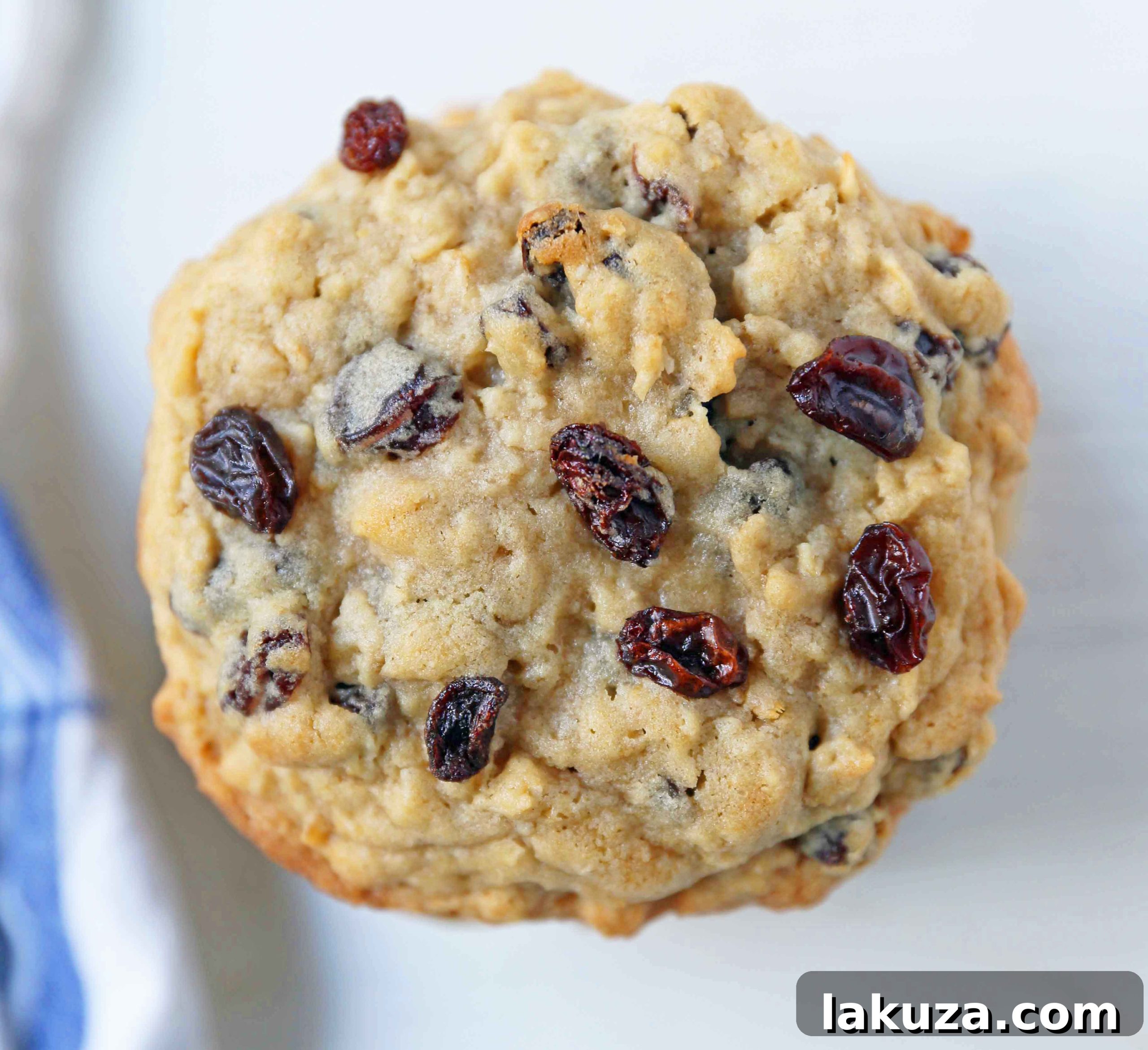 Close-up of a stack of freshly baked Levain Bakery-style oatmeal raisin cookies, highlighting their thick and chewy texture and golden raisins.