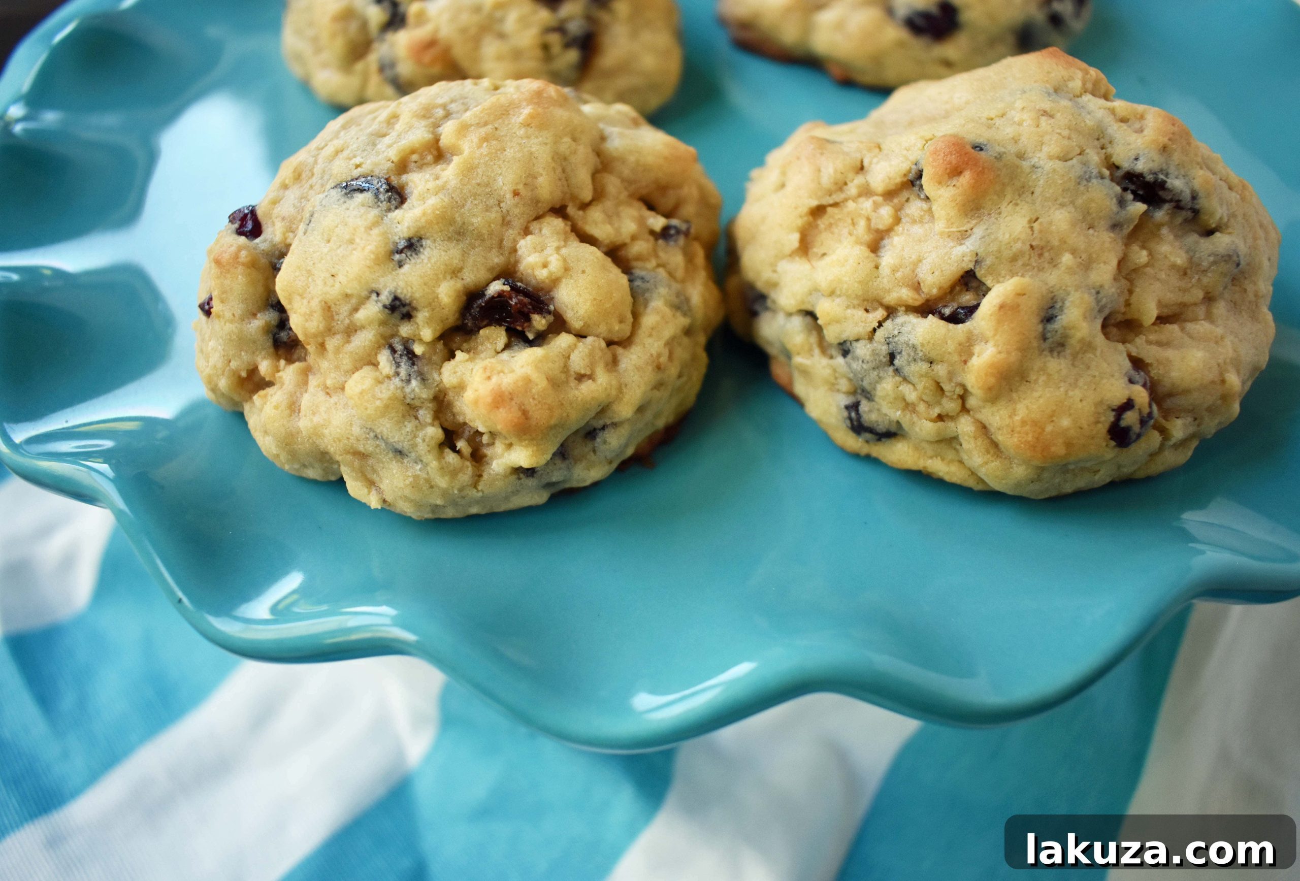 Freshly baked oatmeal raisin cookies on a baking sheet, showcasing their rich color and inviting texture.