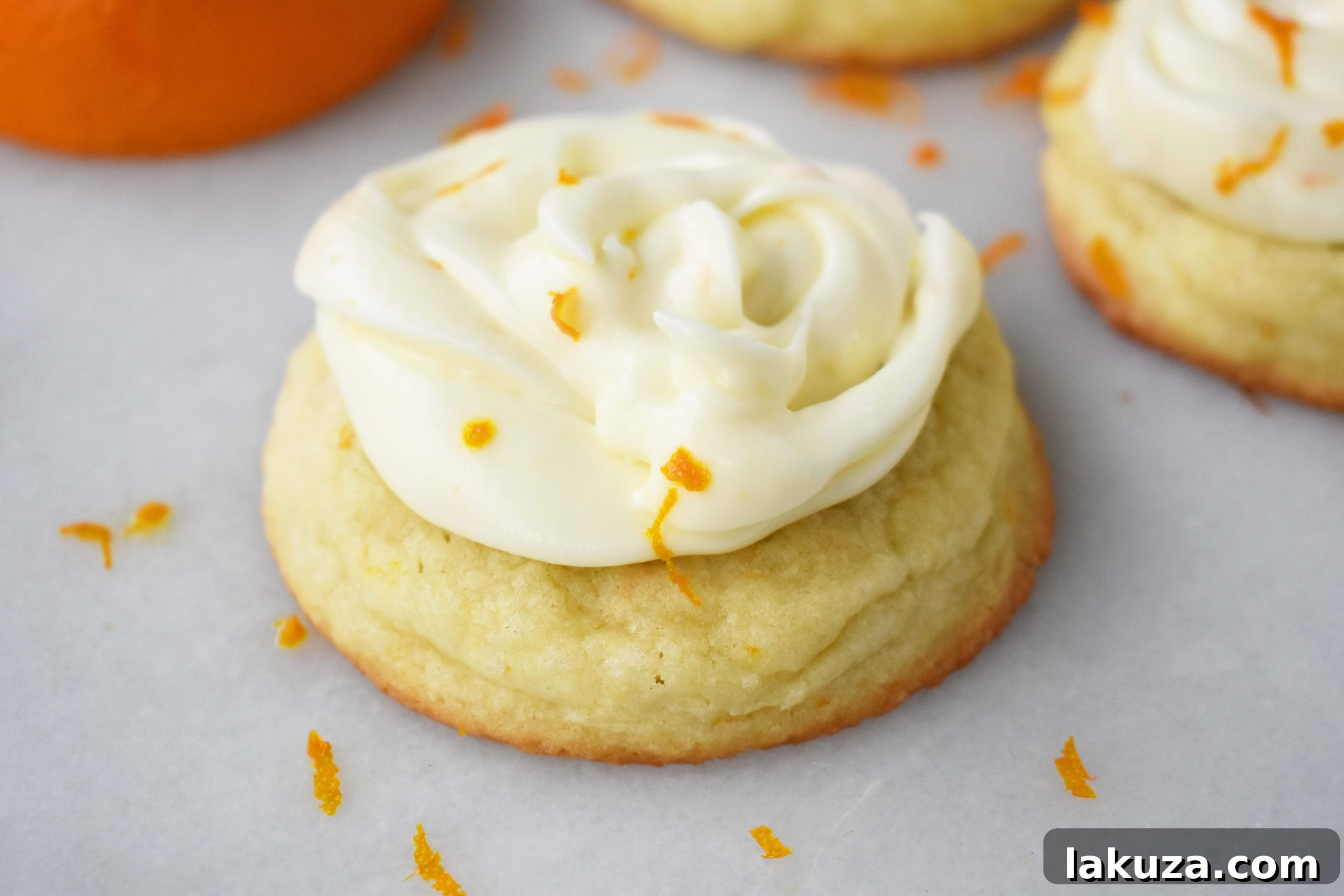 Close-up of a frosted RubySnap Judy Orange Cream Cookie, highlighting the soft orange dough and creamy orange zest frosting.