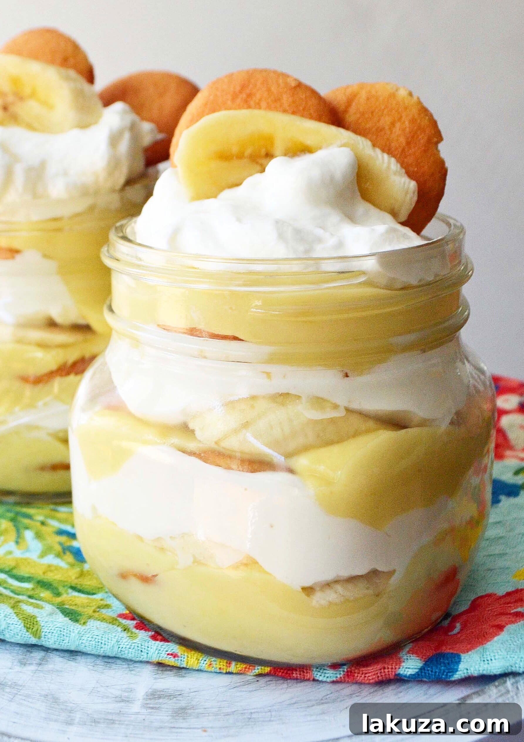 Detailed shot of Homemade Banana Pudding Recipe. Features creamy vanilla bean custard, delicate Nilla wafers, and fluffy whipped cream, showcasing the beautiful layers of this comforting dessert. Perfect for any occasion.