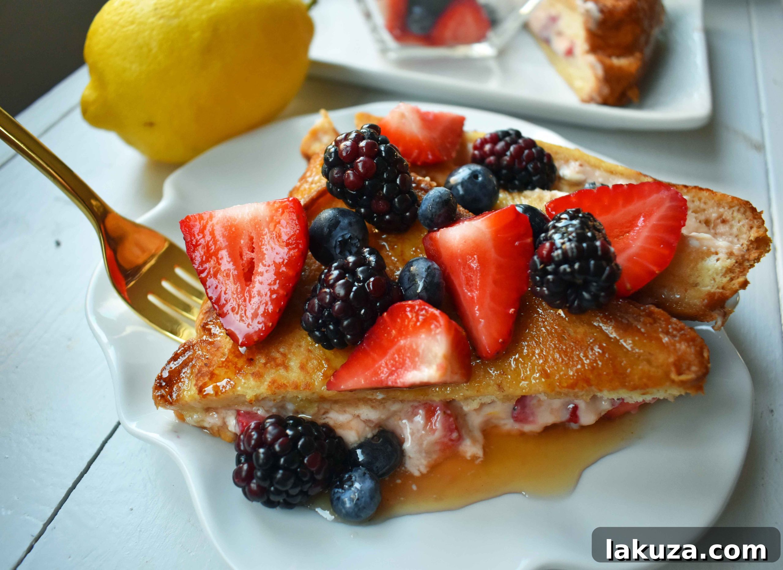 Close-up shot of Strawberries and Cream Stuffed French Toast, showing the creamy filling and fresh strawberry slices.