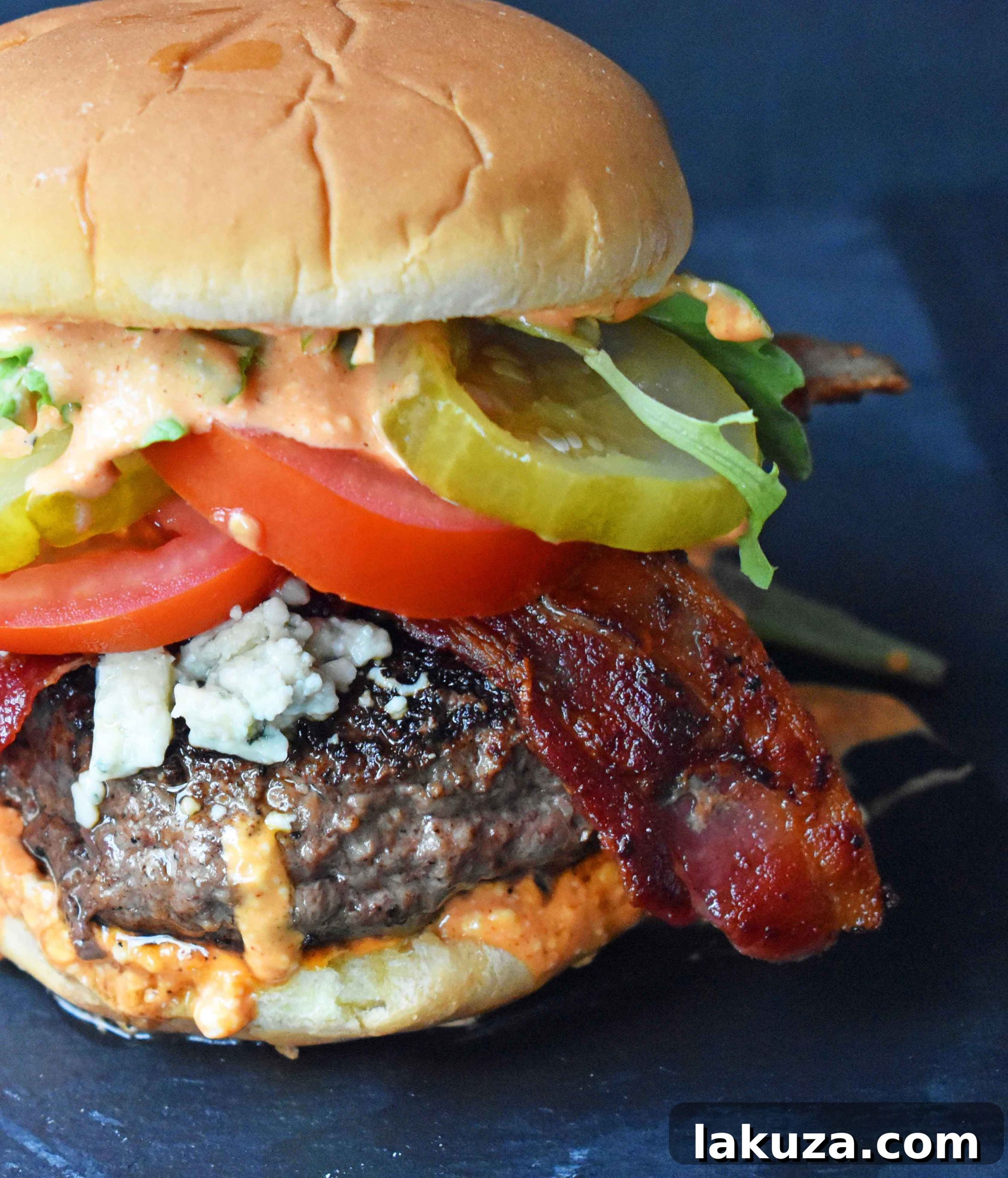 The Wyrmbane Burger 3 Dragonslayer Burger. Beef with blue cheese, crispy bacon, juicy tomatoes, crunchy pickles, spring mix, and buffalo ranch sauce. The ultimate gourmet burger recipe.