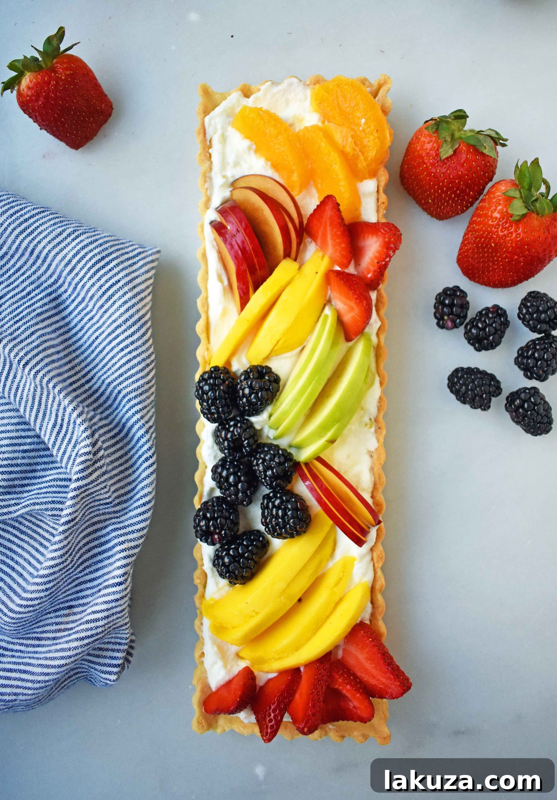 A slice of Fresh Fruit Tart highlights the delicate balance of crispy crust, creamy vanilla filling, and juicy fruit.