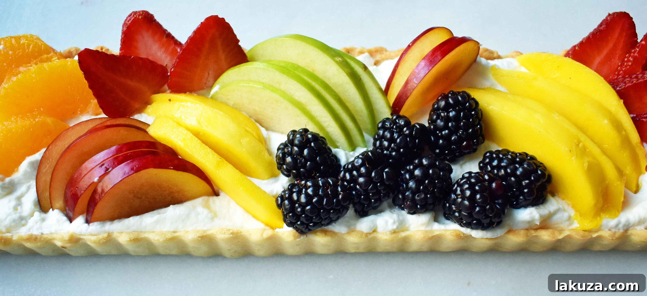 Overview shot of a fruit tart, showcasing the varied textures and colors of the fresh fruit topping, perfect for any occasion.