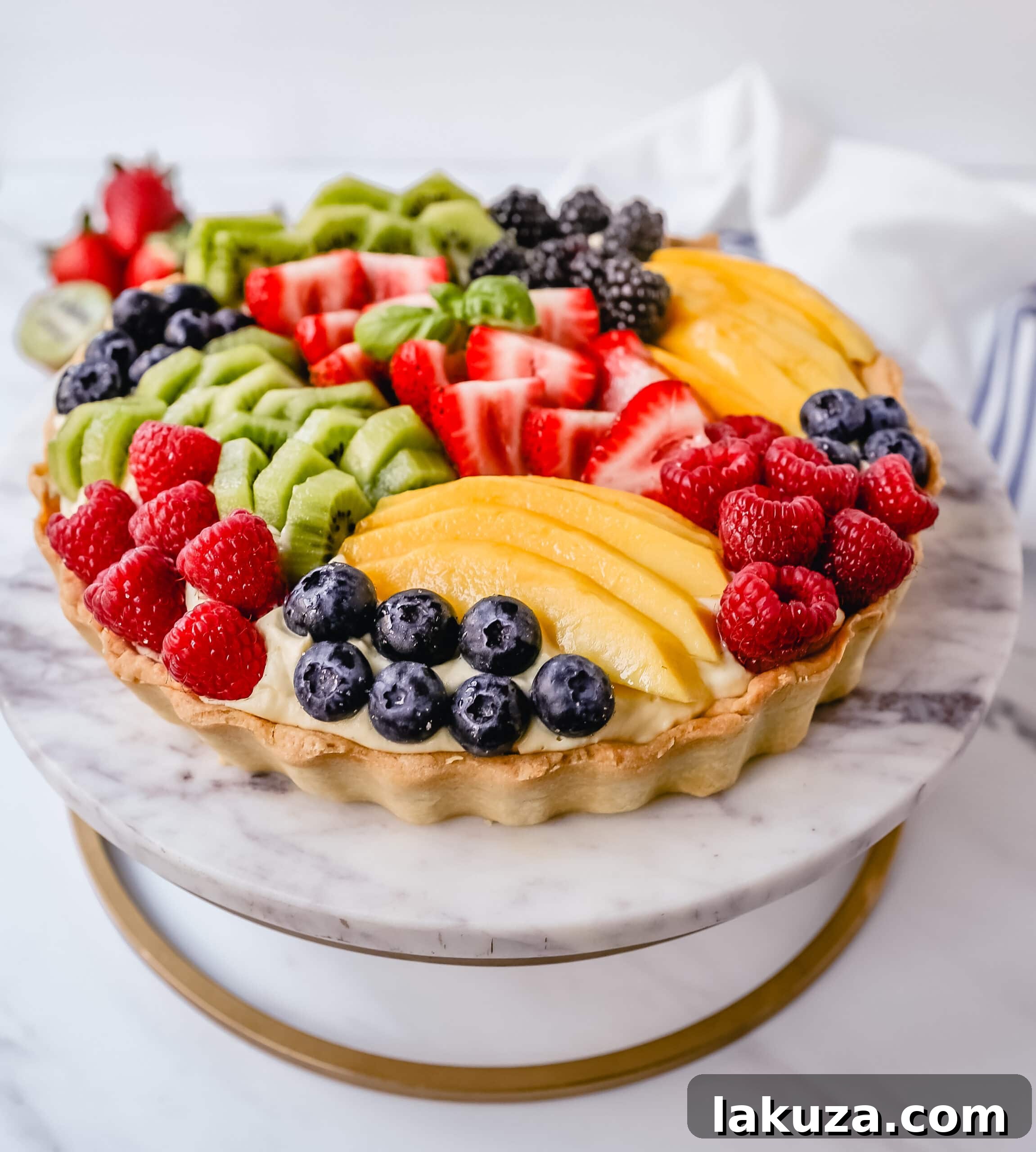 Assortment of vibrant fresh fruits like strawberries, blueberries, kiwi, and raspberries, perfect for a fruit tart topping.