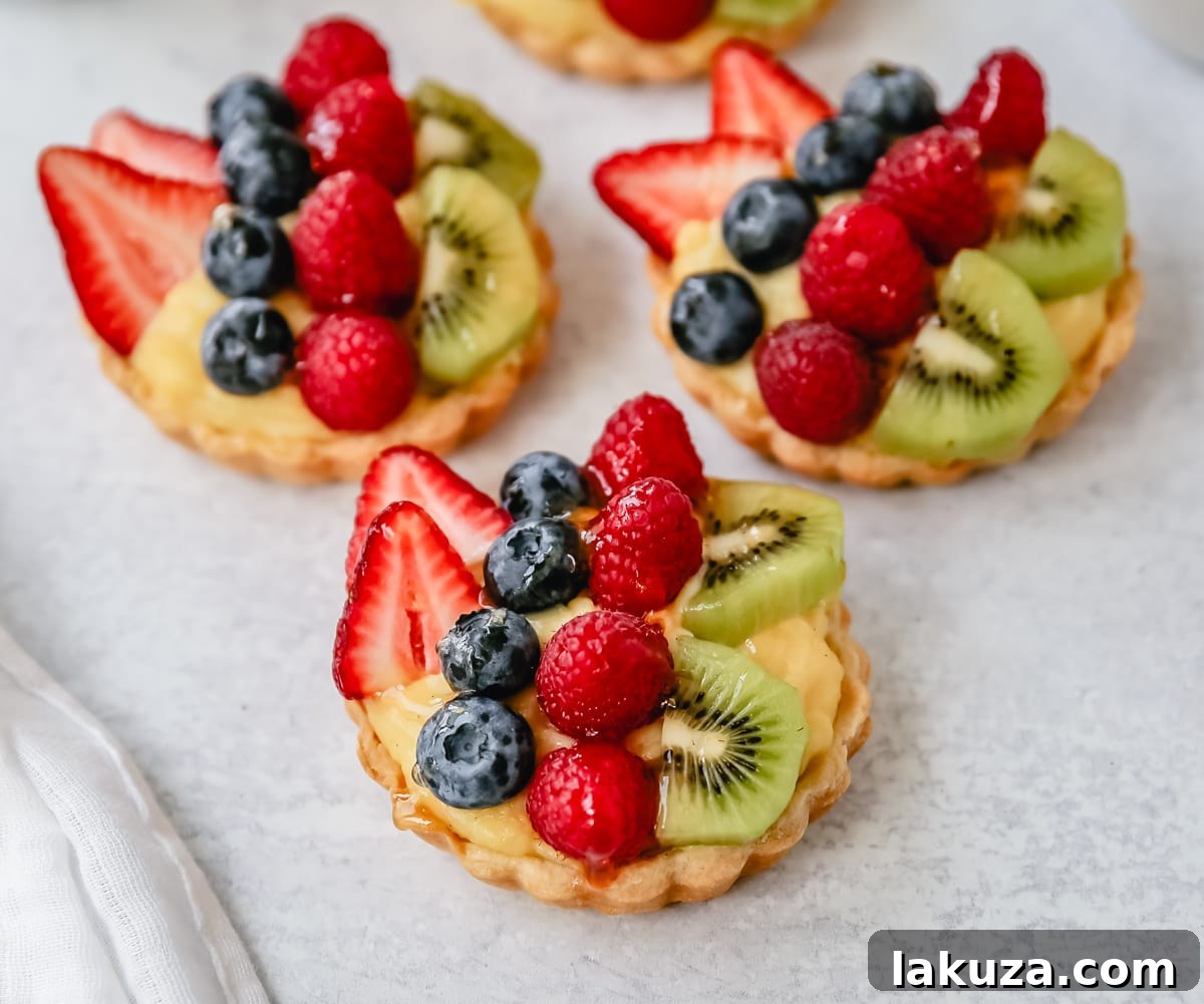 Perfectly smooth vanilla bean pastry cream covered with plastic wrap, chilling in a bowl to prevent skin formation.