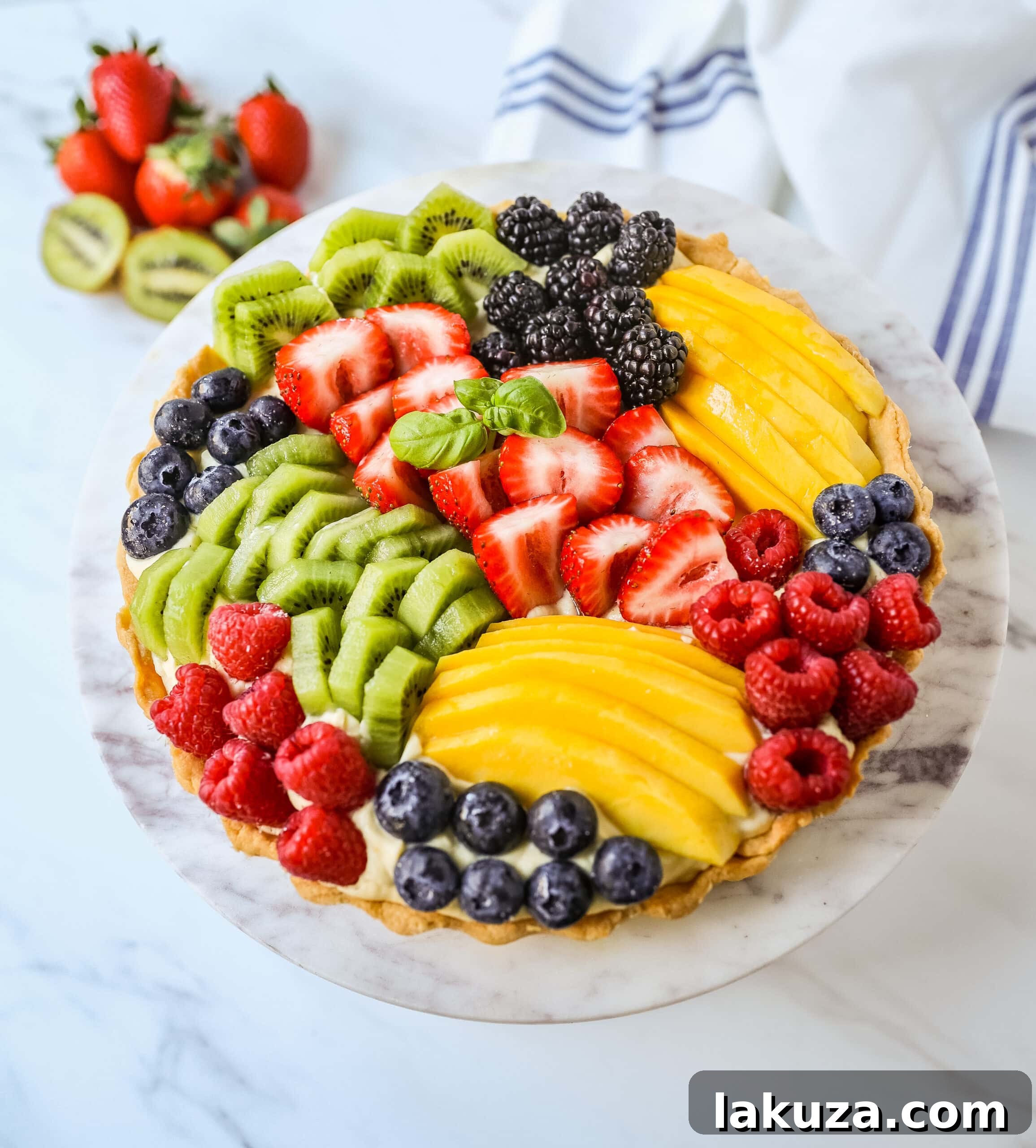 Assembling a fruit tart: spreading vanilla pastry cream into a golden-baked crust before adding fresh fruit.