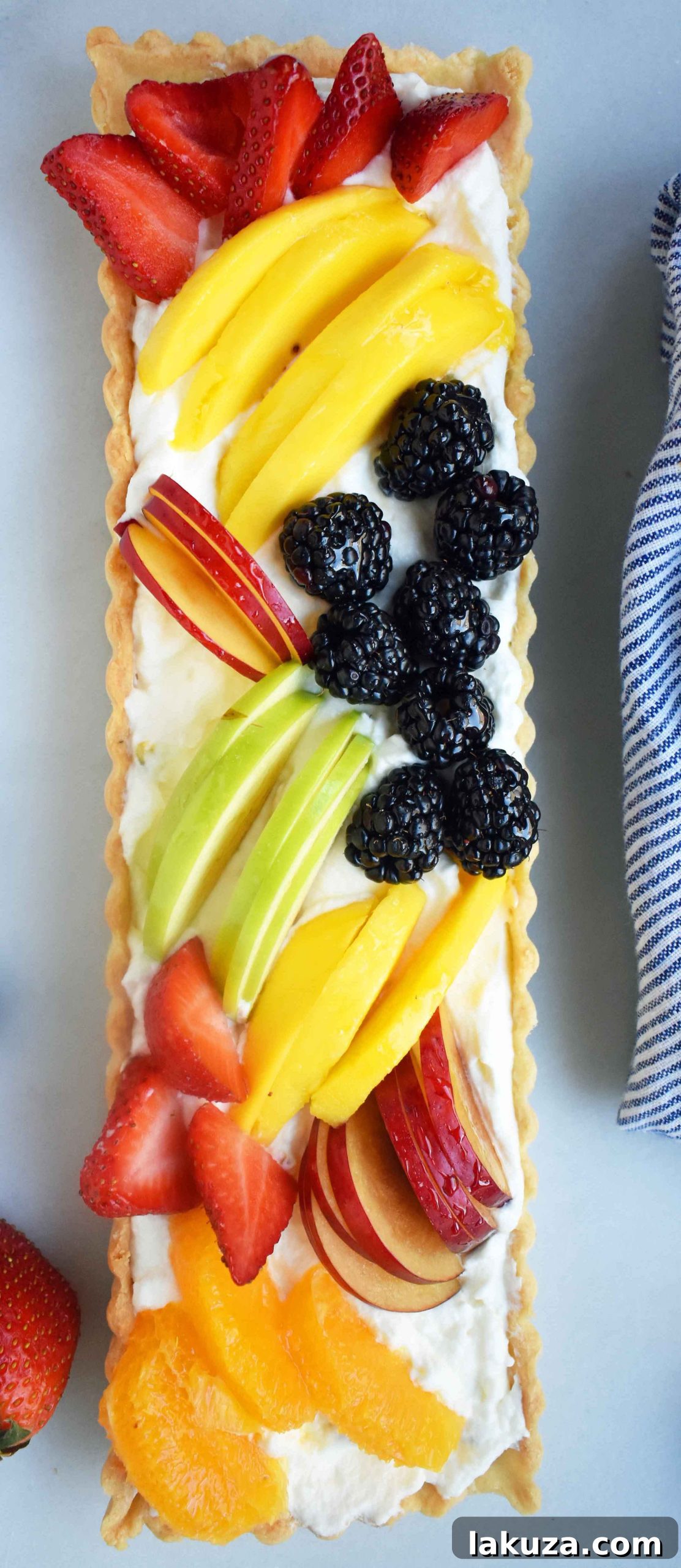 A stunning vertical shot of a Fresh Fruit Tart with Vanilla Pastry Cream, showcasing the vibrant fruits and golden crust.