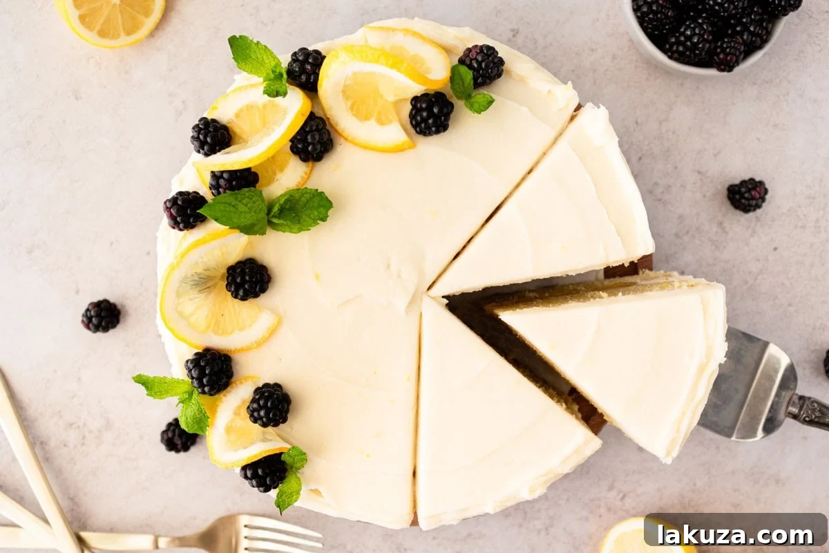 A whole Lemon Olive Oil Cake with cream cheese frosting, elegantly placed on a white cake stand, adorned with lemon slices and berries.