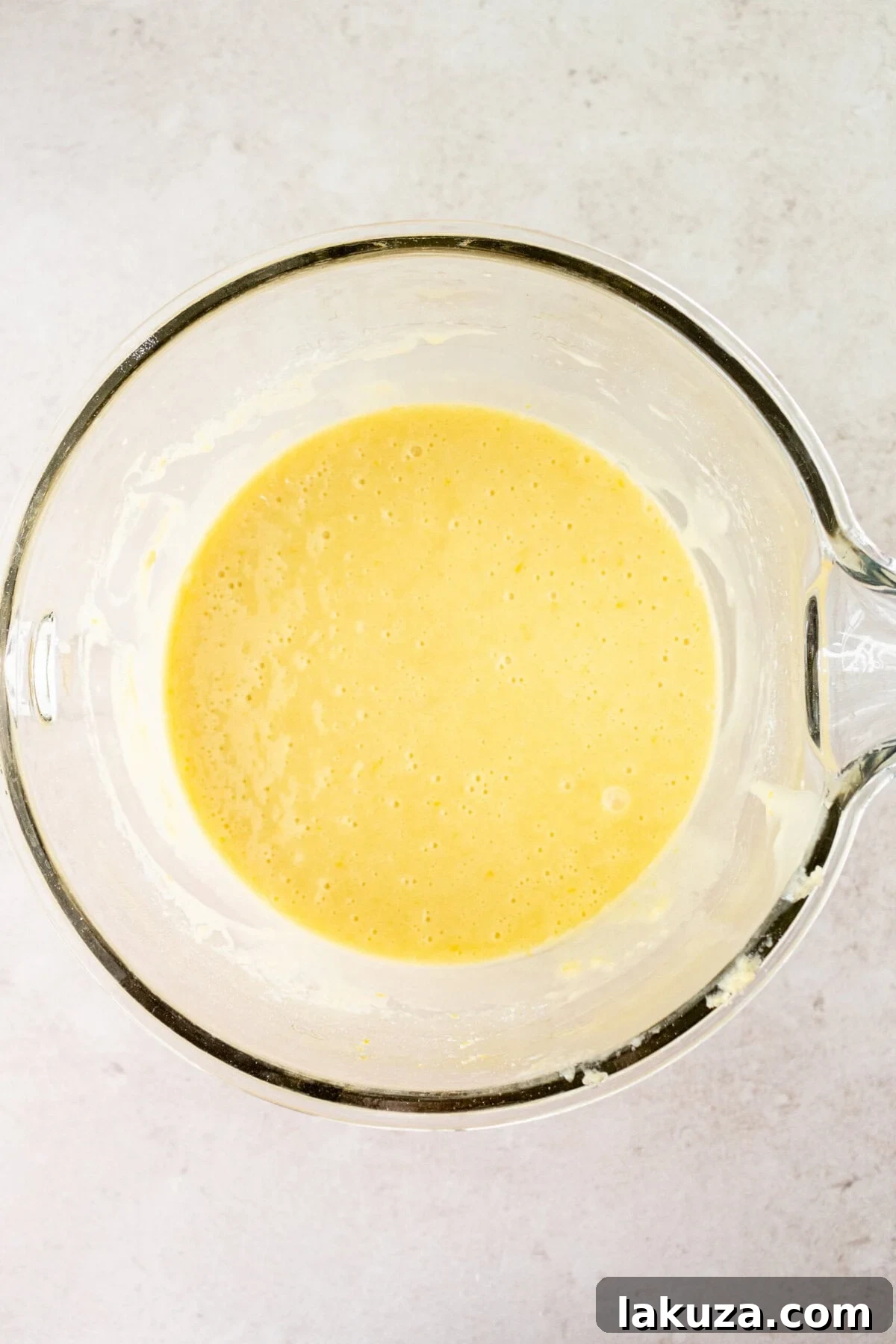 Lemon Olive Oil Cake batter, light yellow and smooth, resting in a large mixing bowl after all ingredients have been combined.