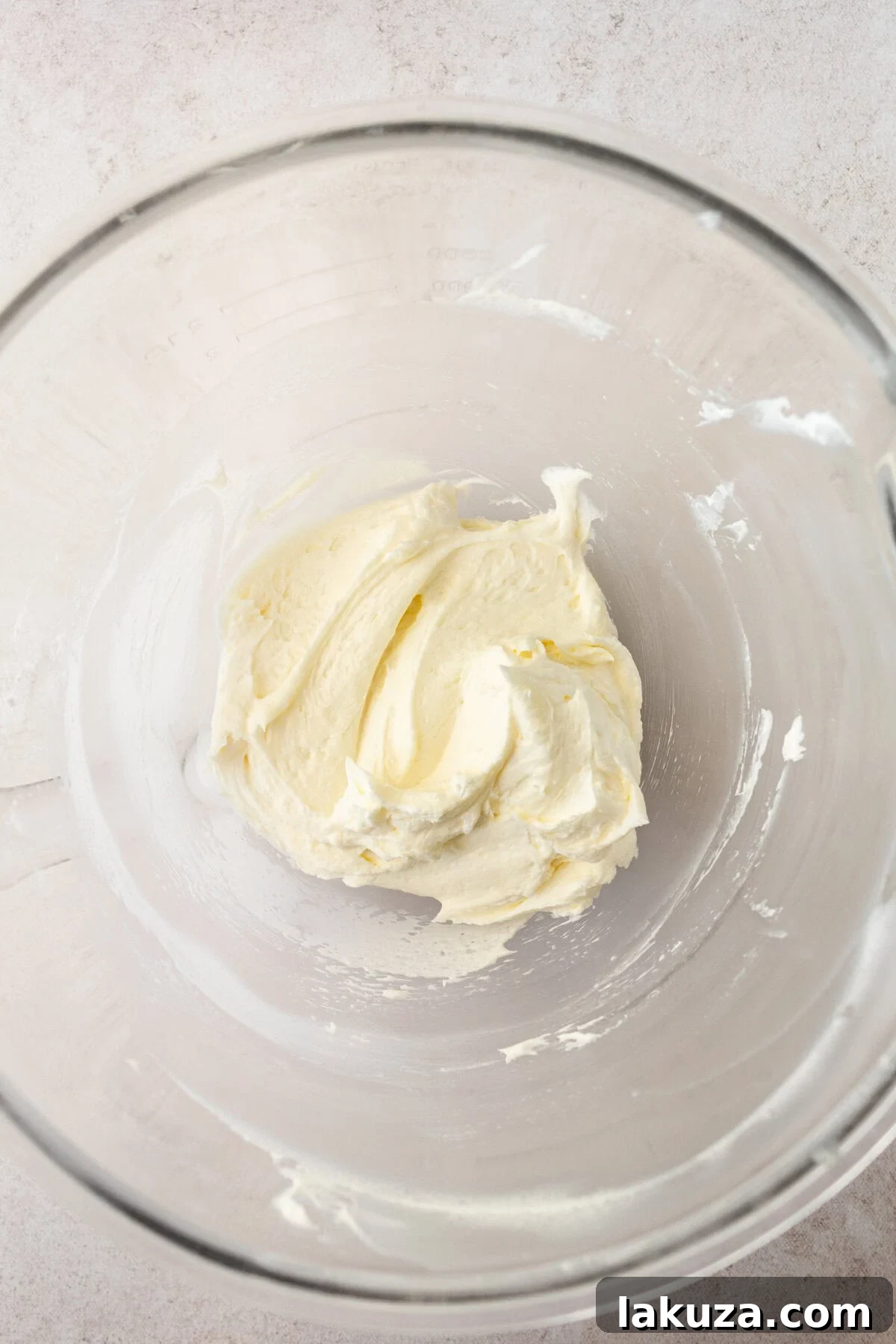 A bowl of creamy lemon vanilla cream cheese frosting, perfectly whipped and ready to be spread onto the cake.
