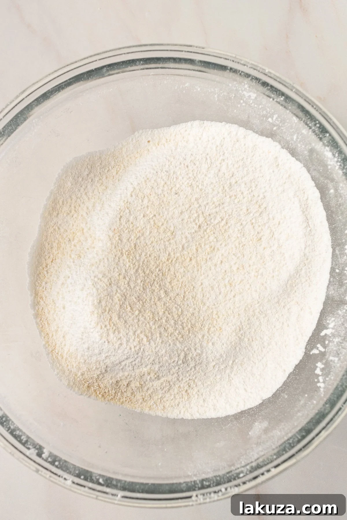 Elegant Macaron Delights 7 Sifting almond flour and powdered sugar into a bowl, a key step for smooth macaron shells.