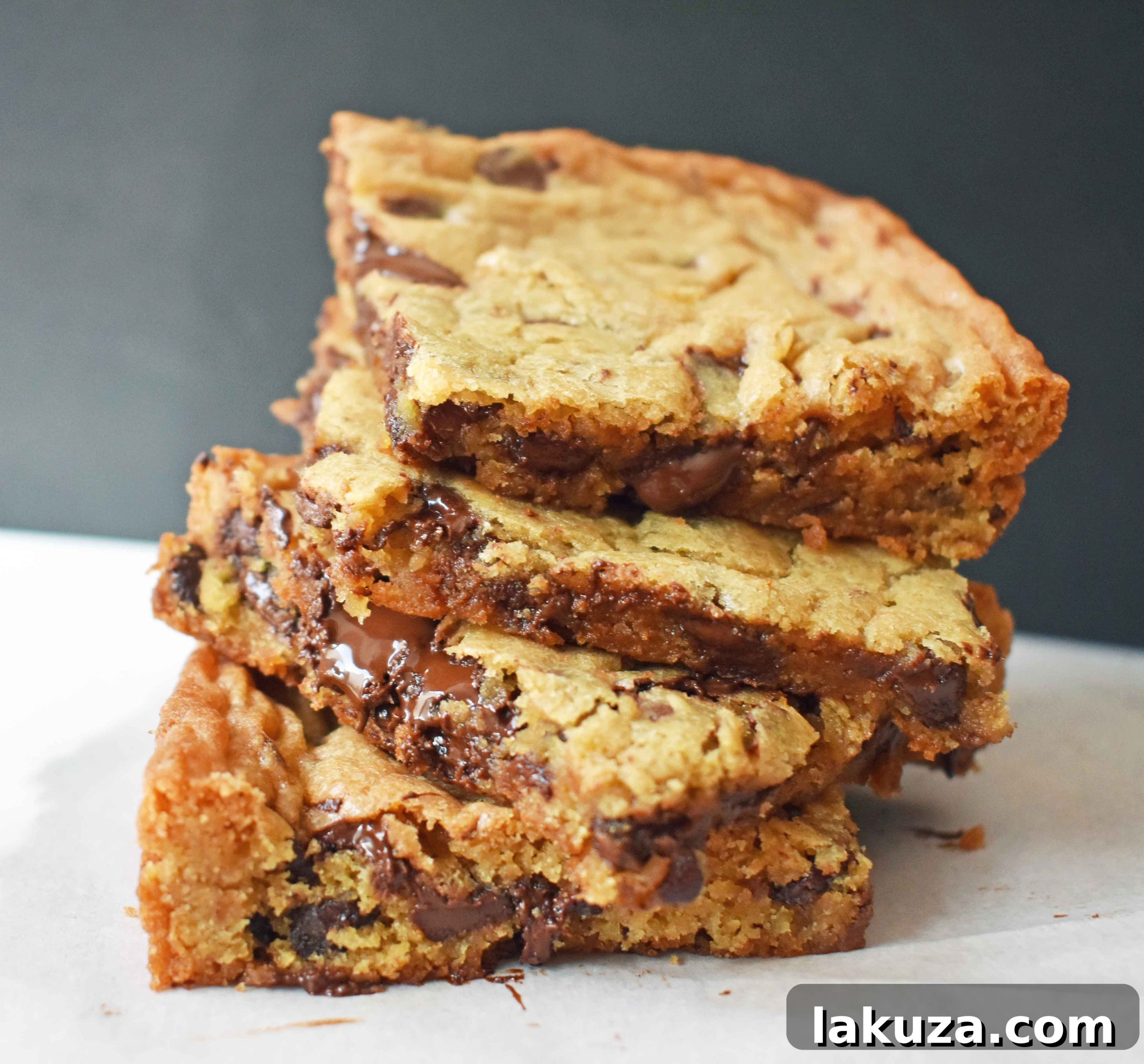 Irresistible Chocolate Chip Bars 4 A pan full of warm, golden brown chocolate chip cookie bars, showing their soft centers and abundance of chocolate.