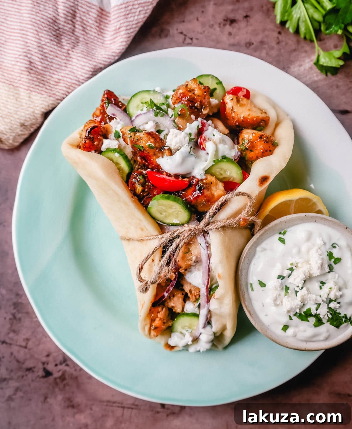 Close-up of a bowl of creamy homemade tzatziki sauce garnished with fresh dill.