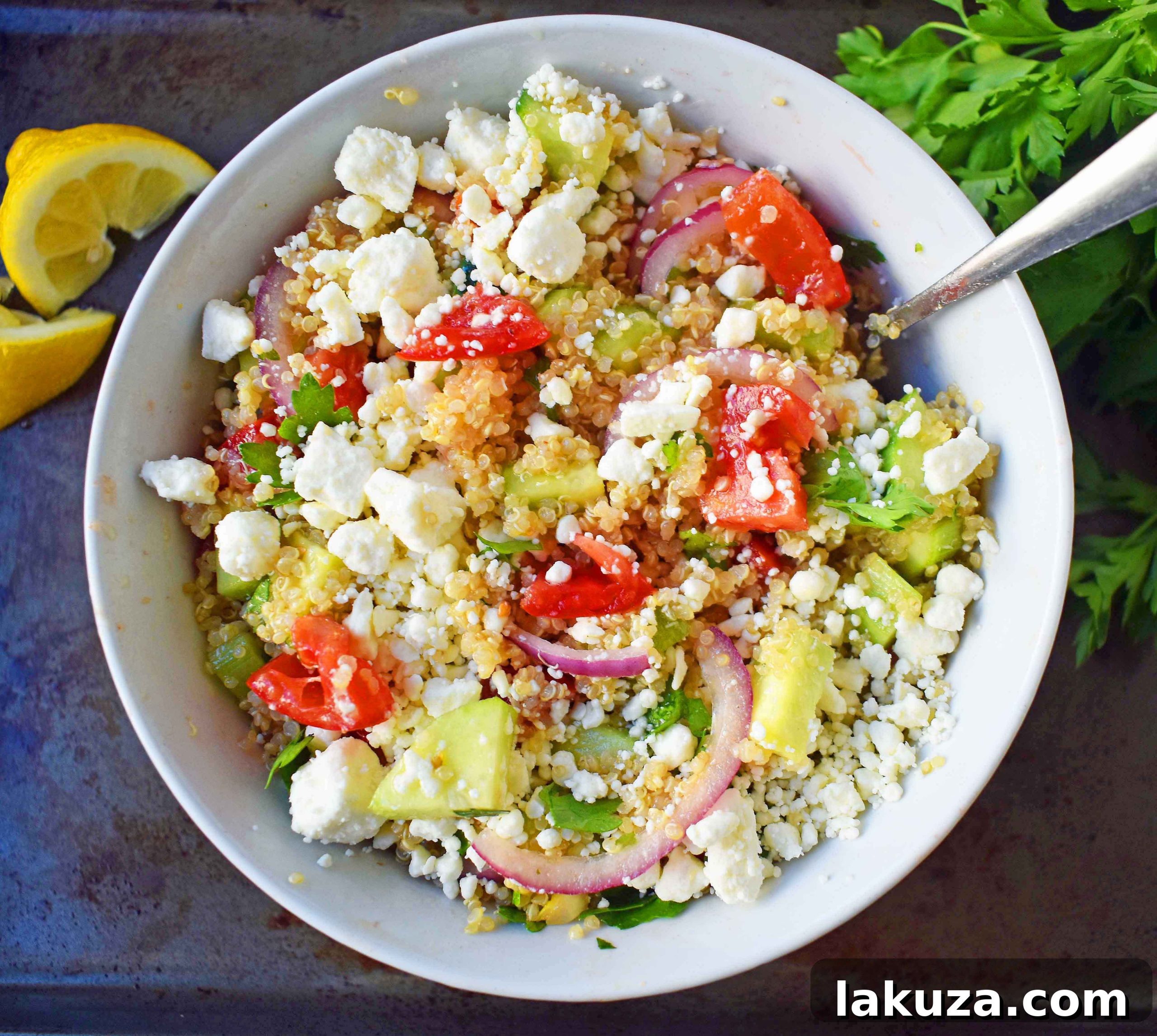 Vibrant Mediterranean Quinoa Salad with crumbled feta, juicy tomatoes, crisp cucumber, and thinly sliced red onions, all dressed in a zesty red wine vinaigrette. A healthy and delicious meal.