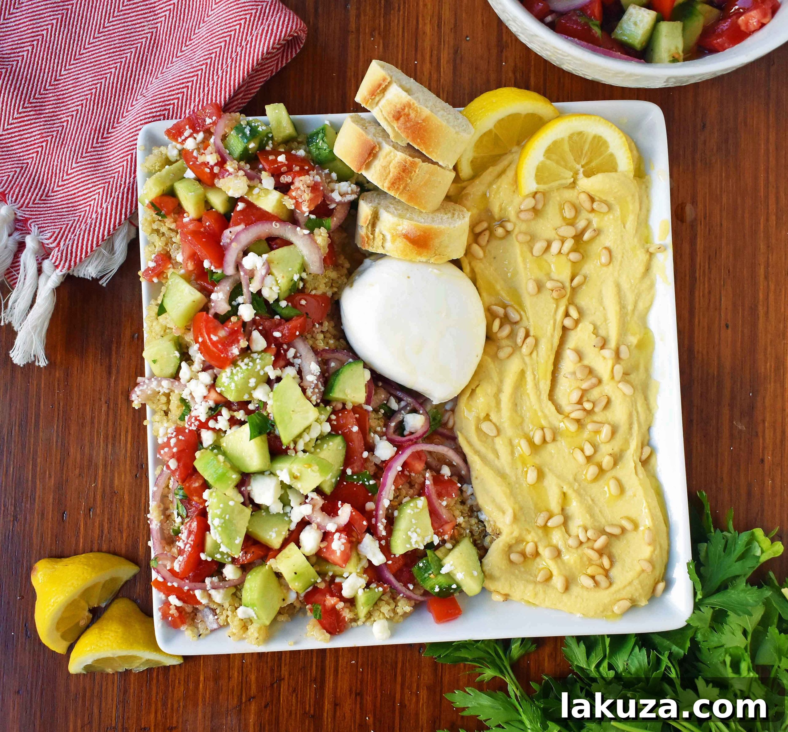 Close-up of Mediterranean Quinoa Salad featuring fluffy quinoa, halved grape tomatoes, diced cucumber, red onion, and fresh Italian parsley, all glistening with extra virgin olive oil and red wine vinegar, topped with crumbled feta cheese. A truly healthy and beautiful salad.
