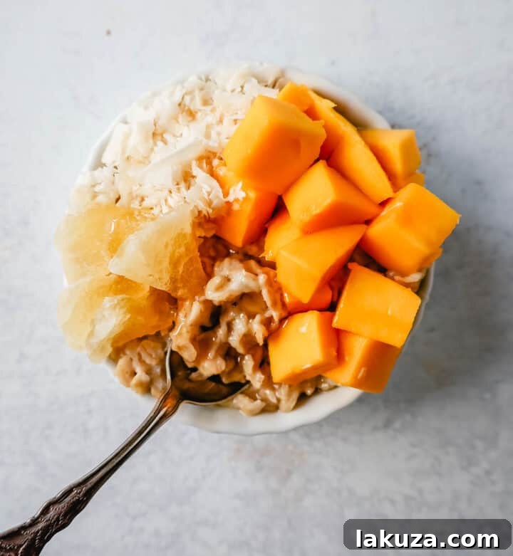 Craft Your Oat Creation 11 Tropical oatmeal with fresh mango, coconut flakes, and dried pineapple, sprinkled with brown sugar.