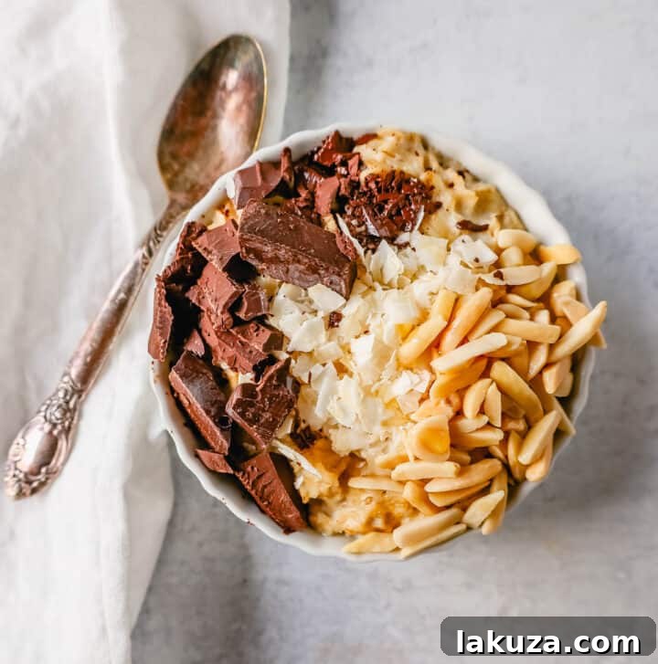 Craft Your Oat Creation 13 Almond Joy oatmeal bowl with coconut flakes, chocolate chunks, and slivered almonds.