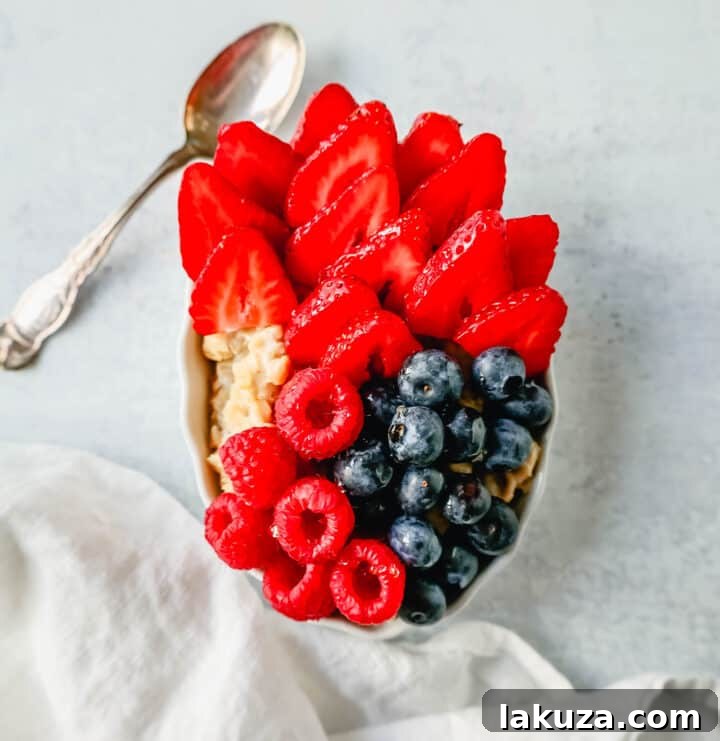 Craft Your Oat Creation 10 Blueberry and strawberry oatmeal drizzled with honey, a sweet and colorful breakfast.
