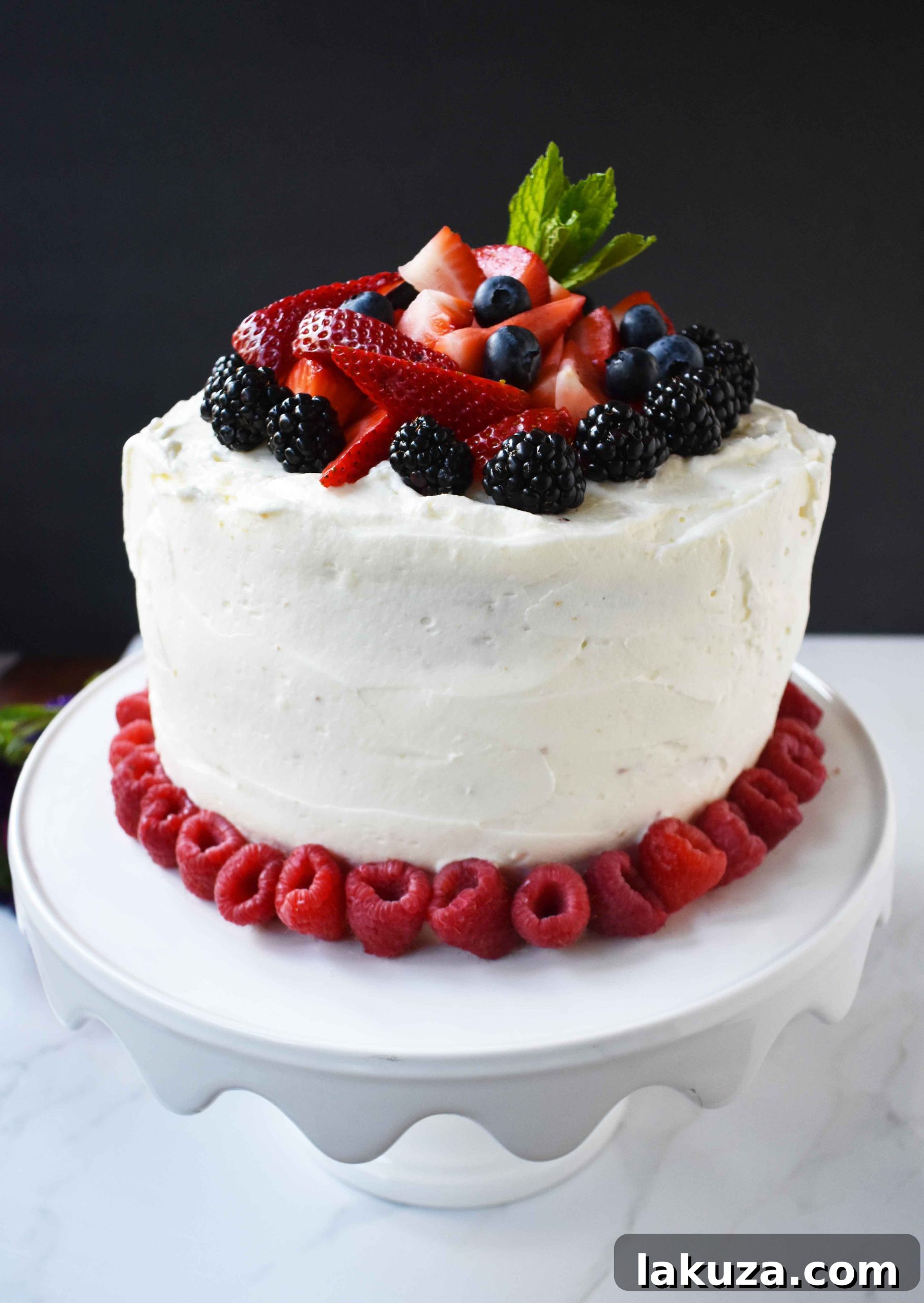 Berry Chantilly Cake 23 A stunning side view of the layered Berry Chantilly Cream Cake, showcasing the fluffy frosting and colorful berries, perfect for a spring or summer gathering.