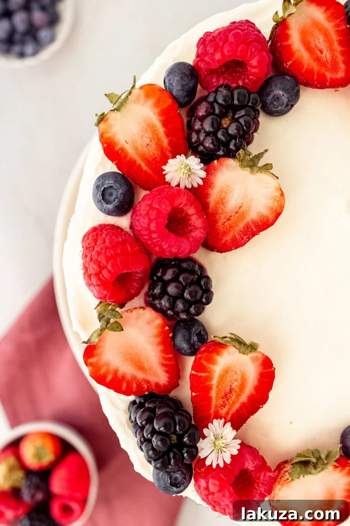 Berry Chantilly Cake 5 Overhead view of a Berry Chantilly Cake showcasing the intricate layers of cake, frosting, and colorful berries on top.