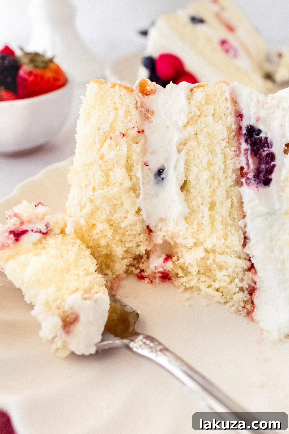 Berry Chantilly Cake 7 Layers of homemade yellow cake coated with a thin layer of jam, Chantilly cream, and fresh berries, ready for the next layer.