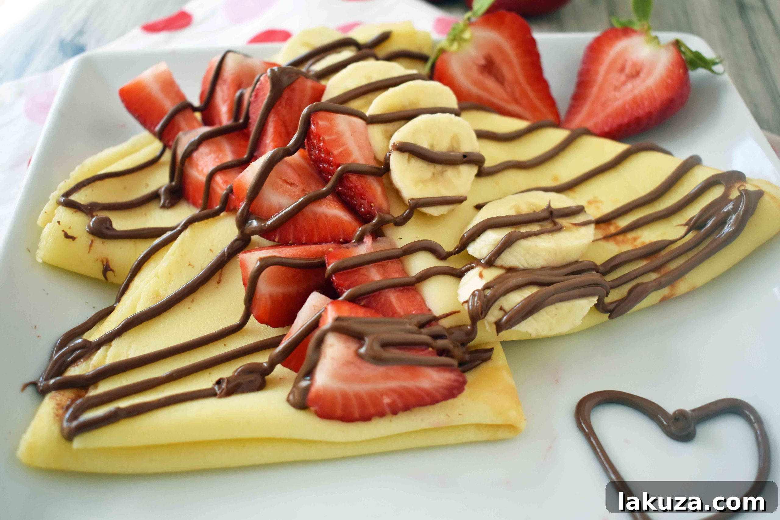 Close-up of golden brown crepes with strawberries and Nutella, showcasing the delicate texture. Modern Honey.