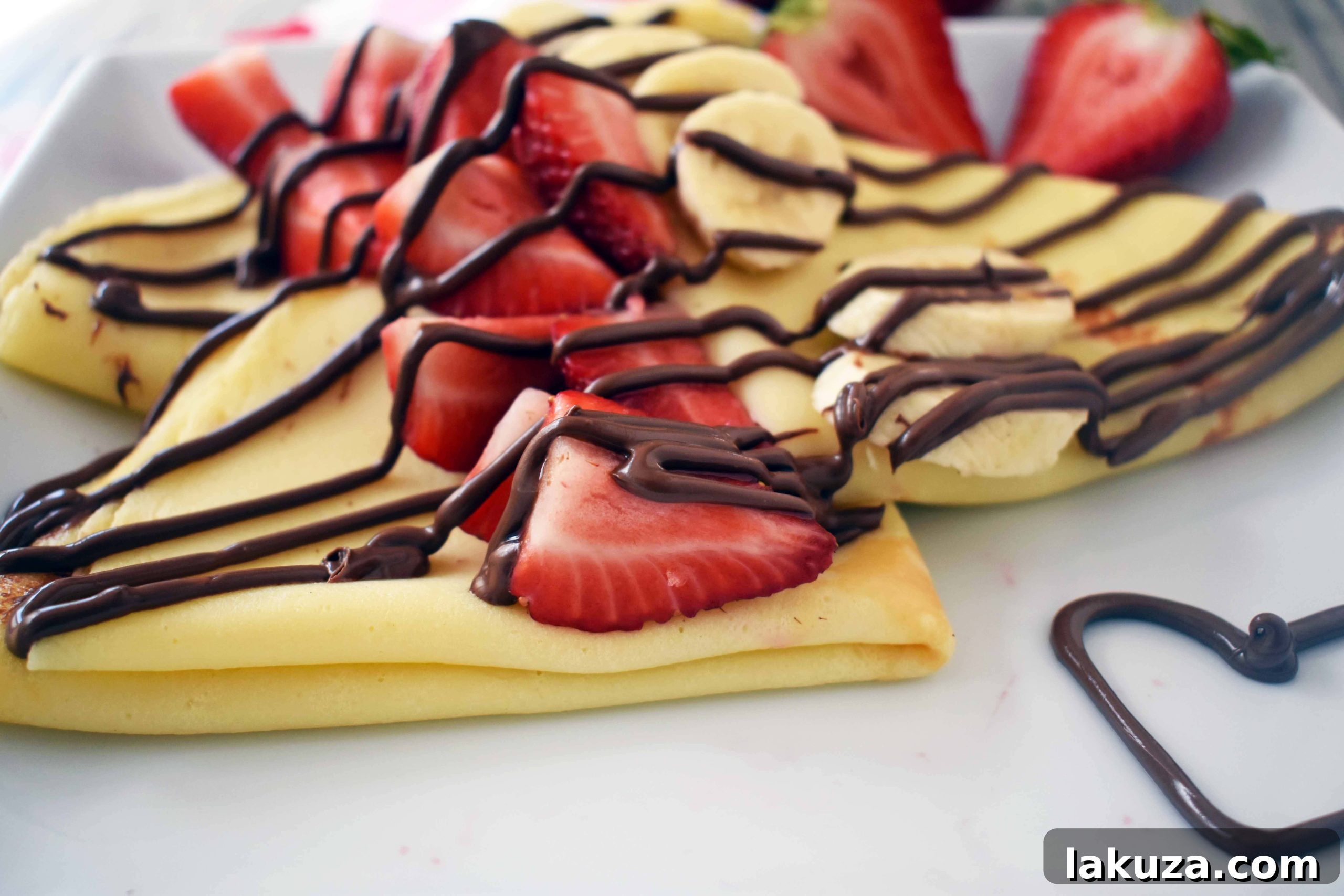 A freshly cooked crepe being gently folded in a non-stick pan, showing its golden-brown color. Modern Honey.