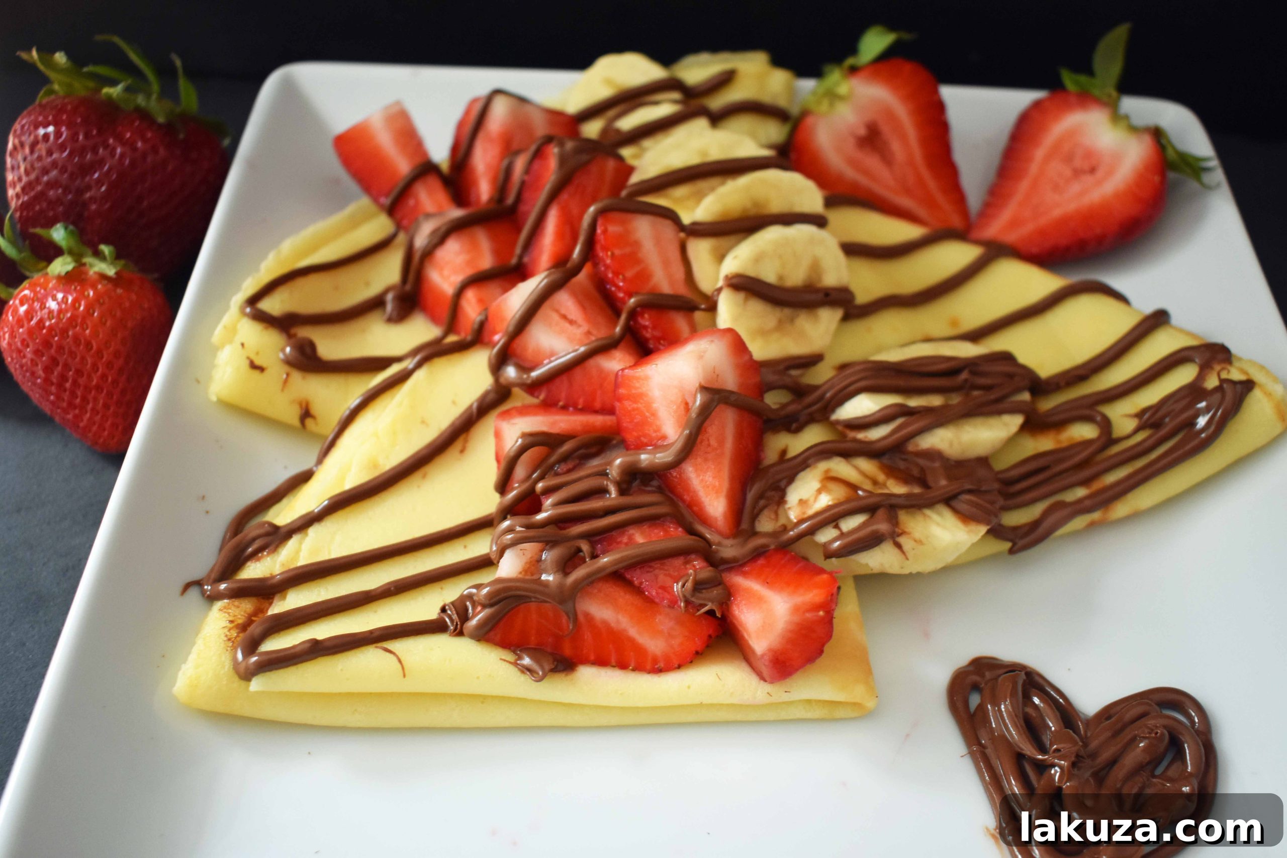 A vibrant selection of crepes topped with fresh strawberries and Nutella, ready to be served. Modern Honey.