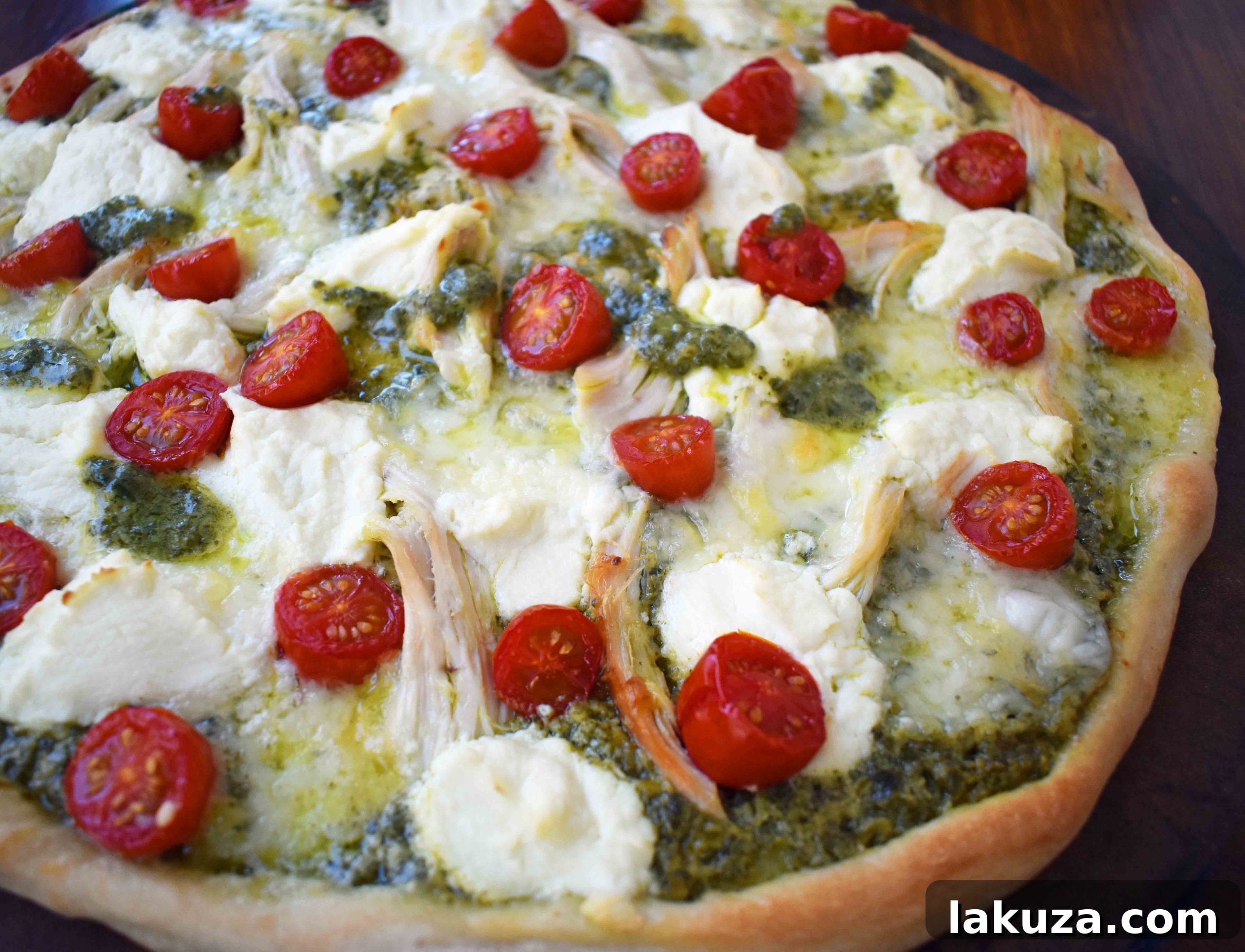 Pre-baked Chicken Pesto Pizza topped with rotisserie chicken, ricotta, and mozzarella.